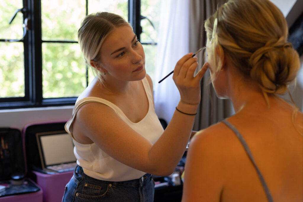 Bridesmaid having makeup done on day of wedding 
